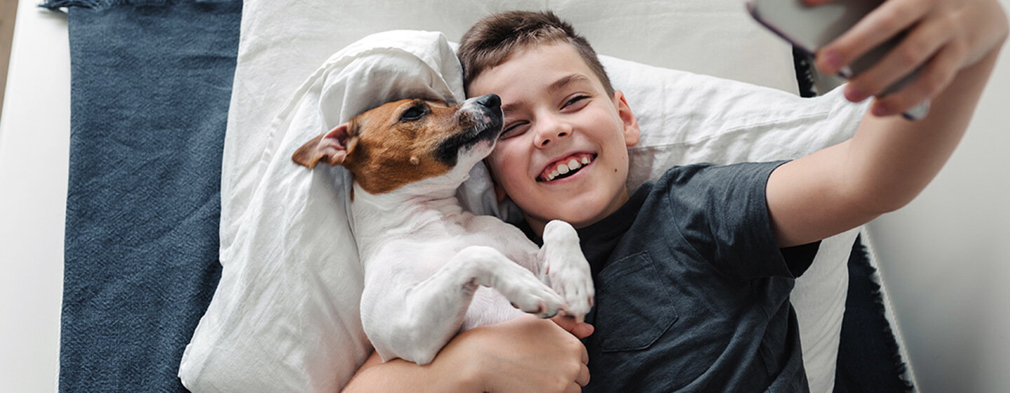 jongen die een selfie met zijn hond neemt