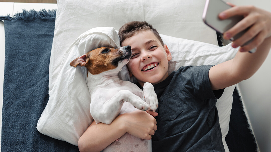 jongen die een selfie met zijn hond neemt