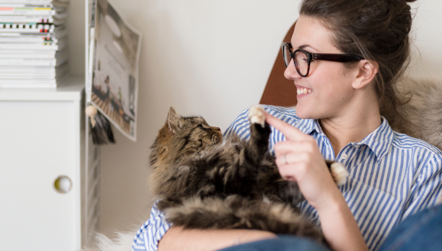 Een vrouw zat met haar kat op schoot en raakte de poot aan met haar vinger