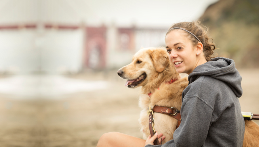 Vrouw zat buiten met haar hond aan de lijn naast haar