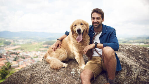 Man met golden retriever op de rots