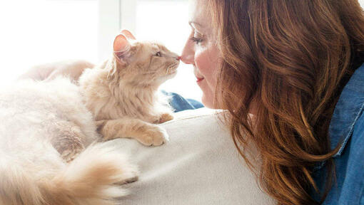 Vrouw en kat zijn aan het neuzen wrijven